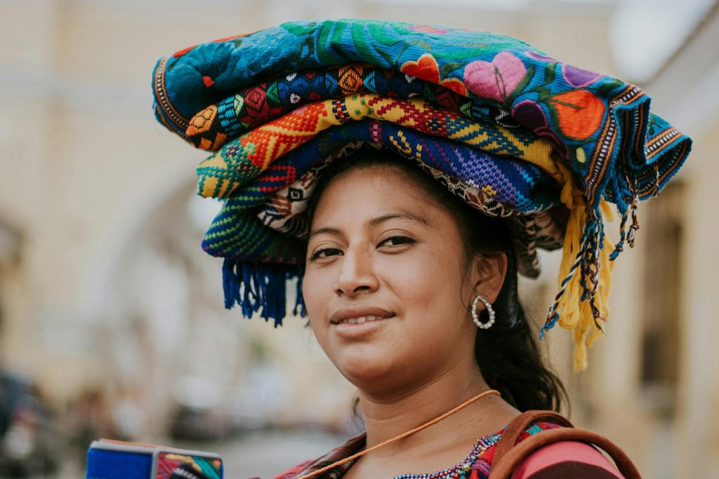 Mujer de Guatemala lleva alfombras y tapetes coloridos sobre su cabeza 1440px