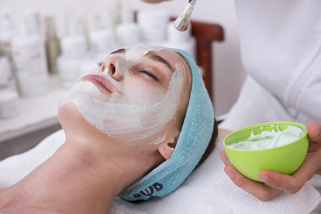 Mujer se aplica máscara facial de belleza en un Spa 1440px